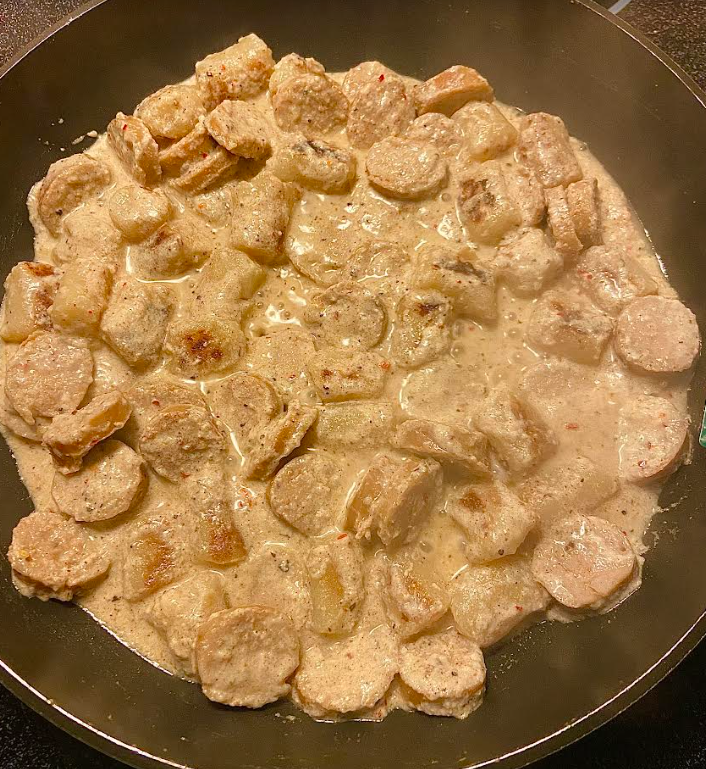 Plato de ñoquis de coliflor cremosos y saludables con hierbas frescas en un entorno otoñal.